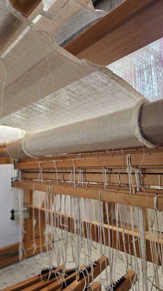 weaving loom with thin linen fabric on it